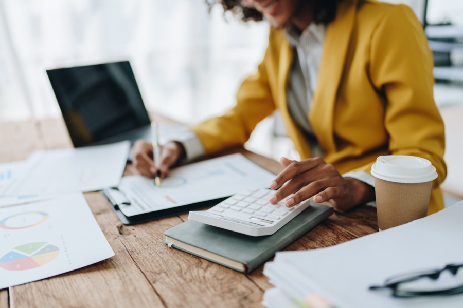 A nonprofit operator reviewing financial papers with a calculator